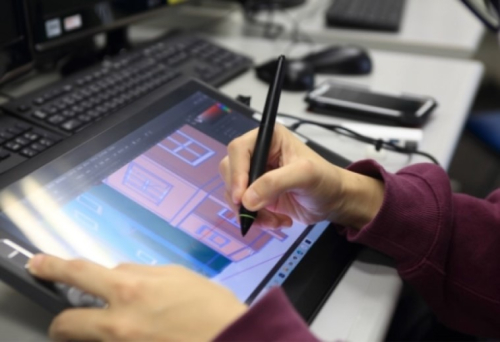 液晶タブレットでデジタルイラスト（街並み）を描いている様子。